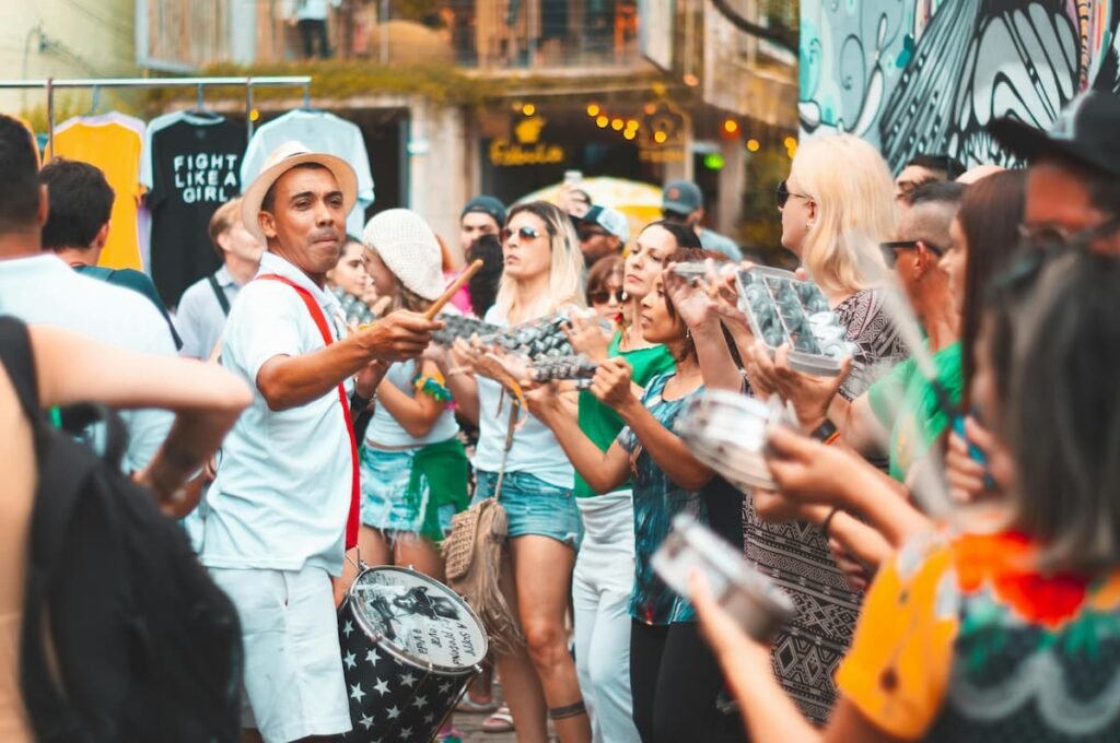 Grupo de foliões cantando em carnaval de rua.