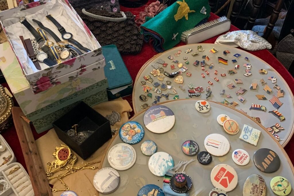 Relógios e bottoms à venda no brechó o Legado da Vó