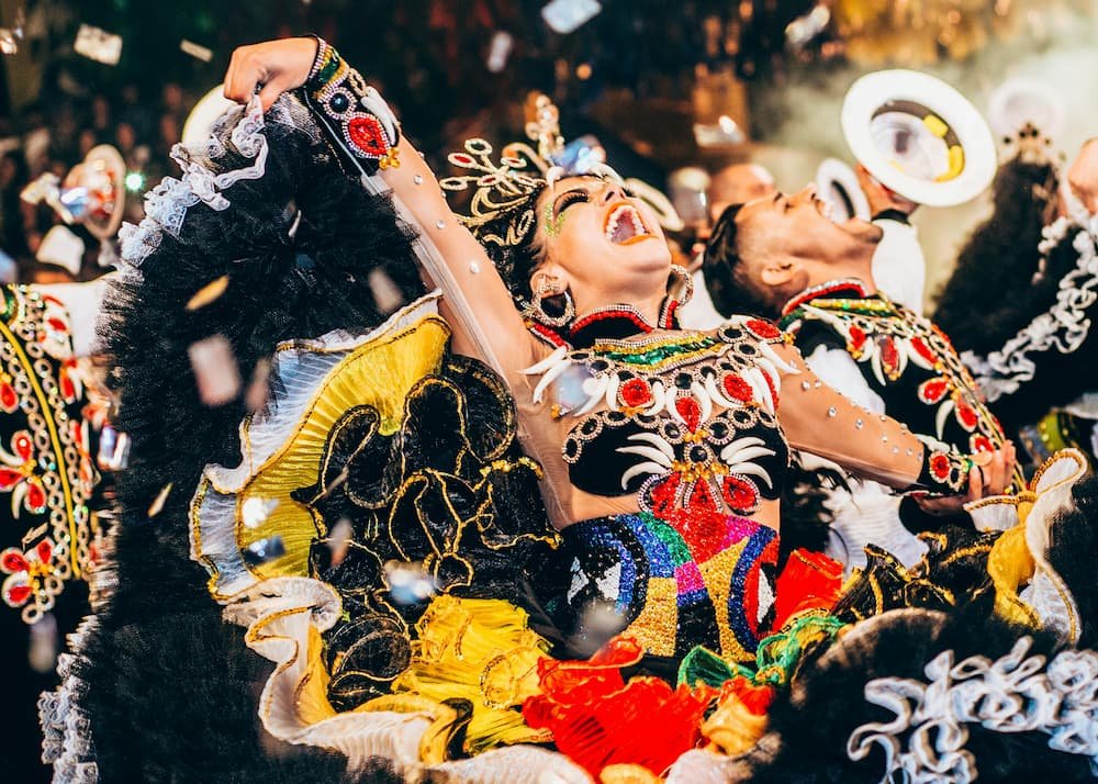 Dançarinos em trajes vibrantes e ornamentados participam de um ensaio de escola de samba.